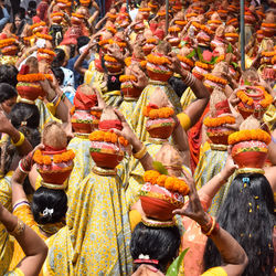 Rear view of females carrying kalasha pot on head
