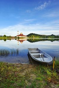 Boat moored on lake against sky
