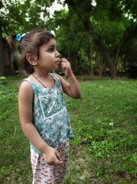 Cute girl looking away while standing on land