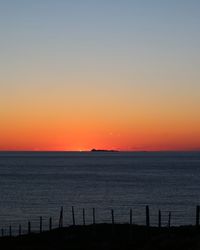 Scenic view of sea against clear sky during sunset