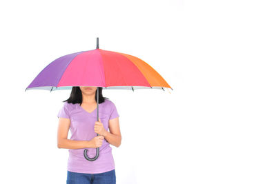 Woman holding umbrella against white background