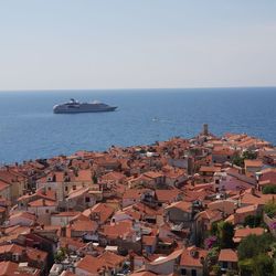 High angle view of sea by buildings against clear sky