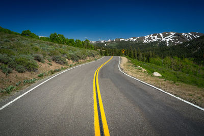 Empty road along countryside landscape