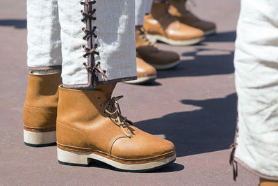 Low section of men standing on footpath 