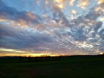 Scenic view of dramatic sky over land during sunset