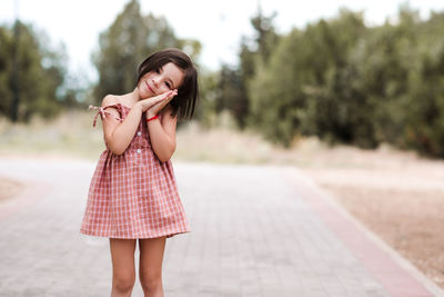 Side view of young woman standing against trees