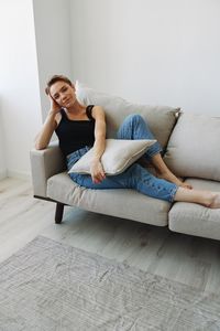 Young woman sitting on sofa at home