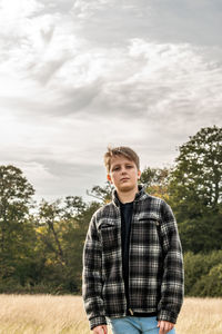 Portrait of young man standing against sky