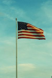 Low angle view of flag against blue sky