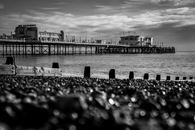 Surface level of worthing pier over river against cloudy sky