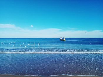 Scenic view of sea against blue sky