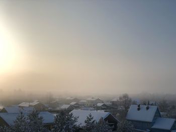 Aerial view of townscape against sky during winter