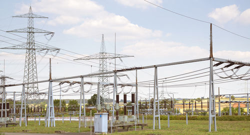 Electricity pylon on field against sky