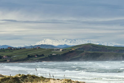 Scenic view of sea and mountains against sky