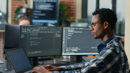 Computer programmer working on computer