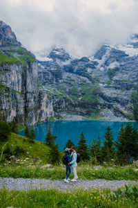 Rear view of people on mountain against sky