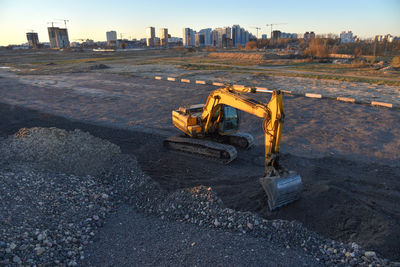 Construction site by road against sky in city