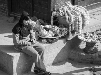 Woman looking at market stall against wall