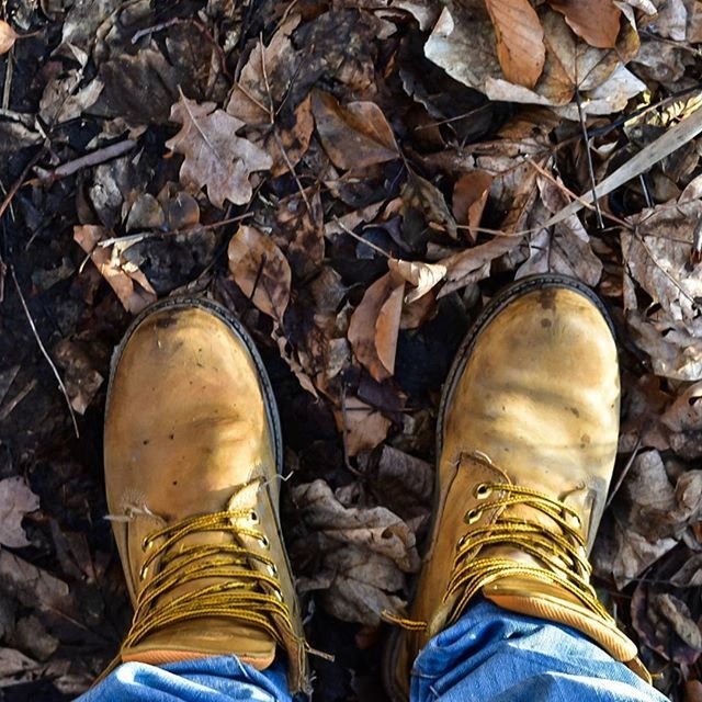 low section, shoe, person, personal perspective, standing, footwear, lifestyles, human foot, jeans, men, high angle view, leaf, leisure activity, directly above, close-up, unrecognizable person, dry