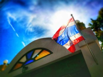 Low angle view of flags against blue sky