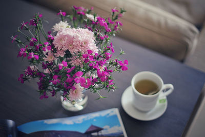 High angle view of flower vase and tea cup on table at home