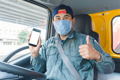 Full length portrait of young man sitting in car