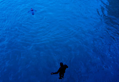 High angle view of silhouette man jumping into river