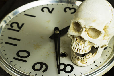 High angle view of human skull on clock