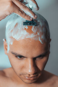 Close-up of man shaving head