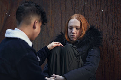 Boy touching and comforting young woman