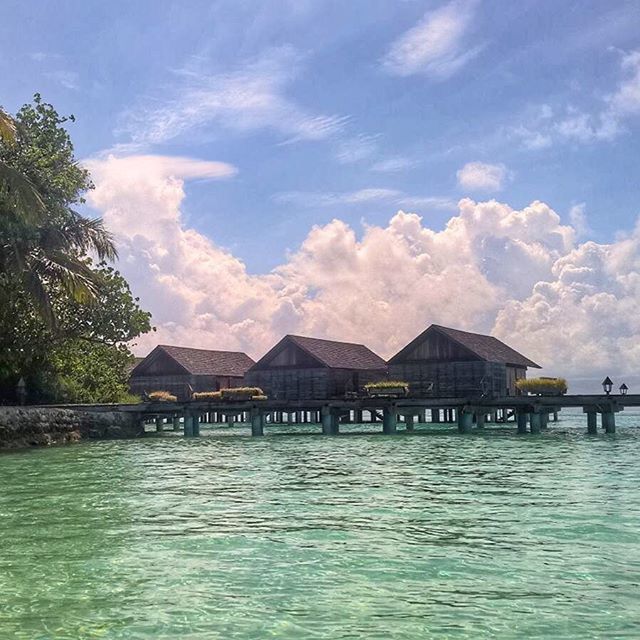 water, built structure, architecture, waterfront, sky, building exterior, cloud - sky, tree, house, tranquil scene, tranquility, cloud, river, rippled, nature, scenics, beauty in nature, pier, lake, mountain