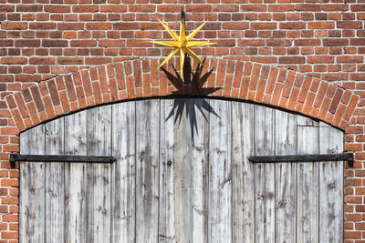 Close-up of open door on brick wall