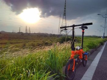 Bicycle parked in farm against sky