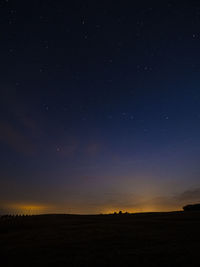 Scenic view of silhouette field against sky at night