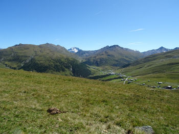 Scenic view of landscape and mountains against blue sky