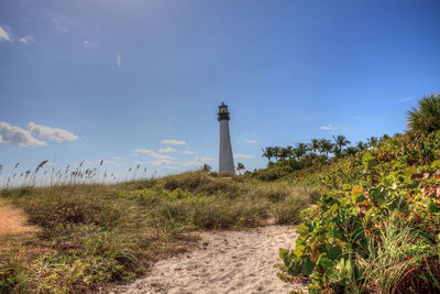 Lighthouse on field against sky