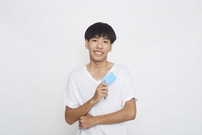 Portrait of smiling man standing against white background