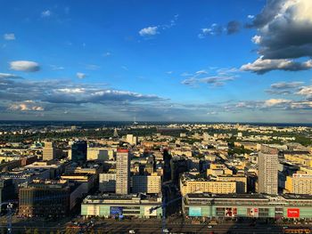 High angle view of city buildings against cloudy sky