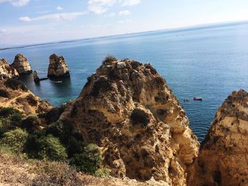 Scenic view of rocks in sea against sky