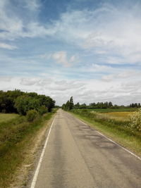 Empty road passing through field