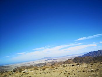 Scenic view of desert against blue sky