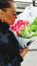 Midsection of woman holding red flower