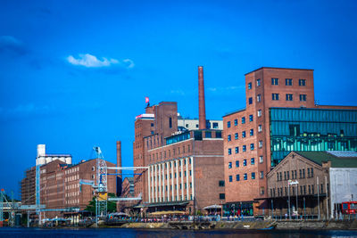 Buildings in city against blue sky