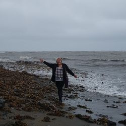 Full length of person standing on beach against sky