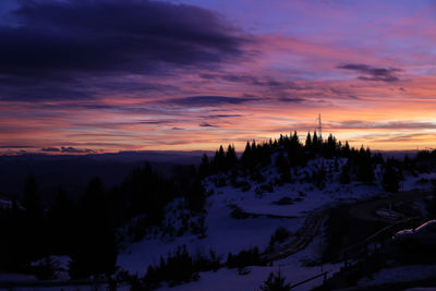 Scenic view of snow covered mountains against orange sky