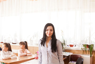 Portrait of a smiling young woman sitting on table