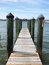 Wooden pier over sea against sky