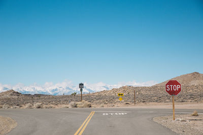 Road sign against clear blue sky