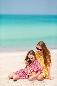Rear view of women sitting on beach