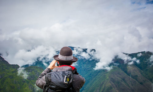 Rear view of woman with mountain range against sky